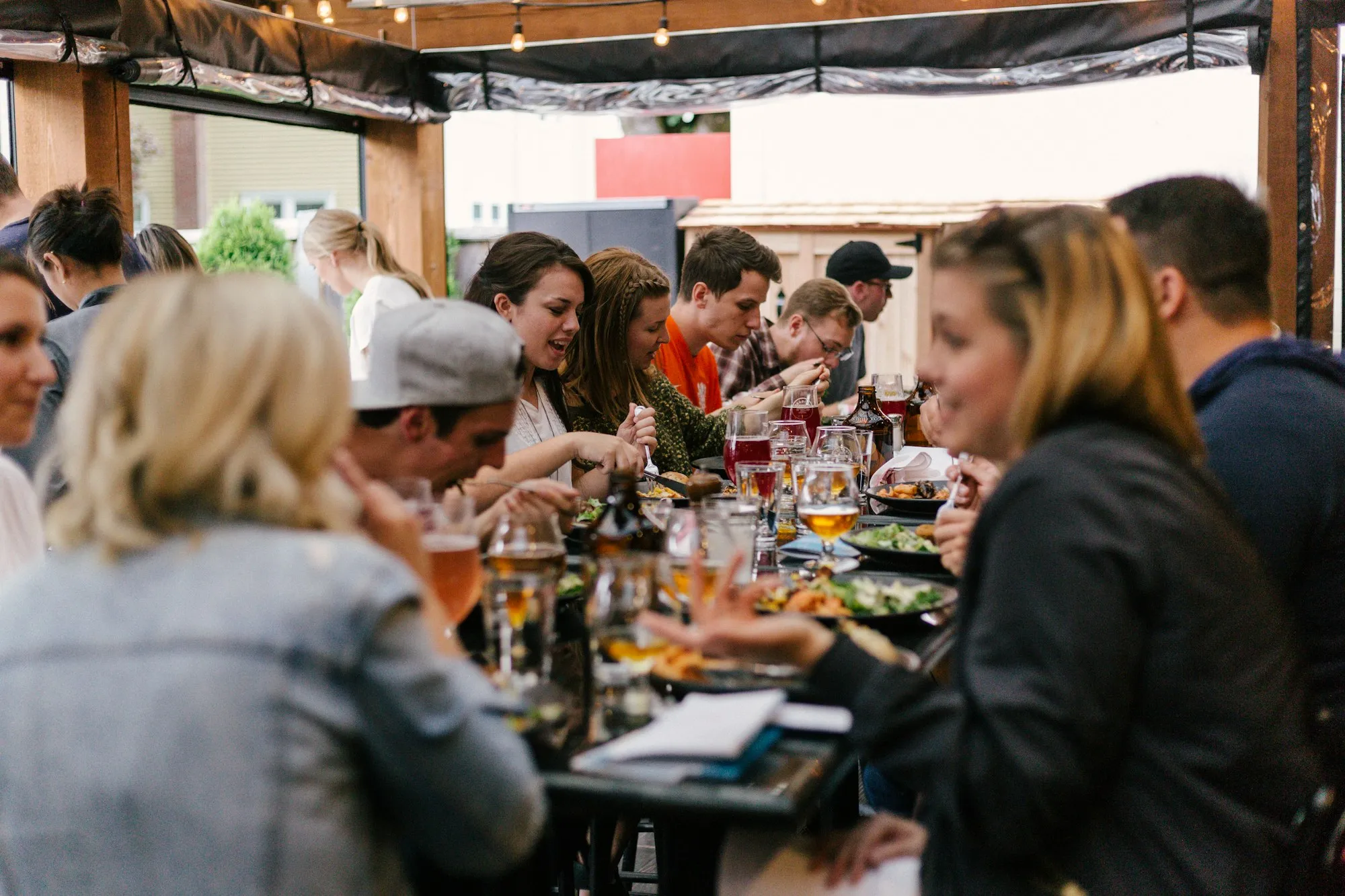 Grupo de amigos conviviendo alrededor de una mesa larga